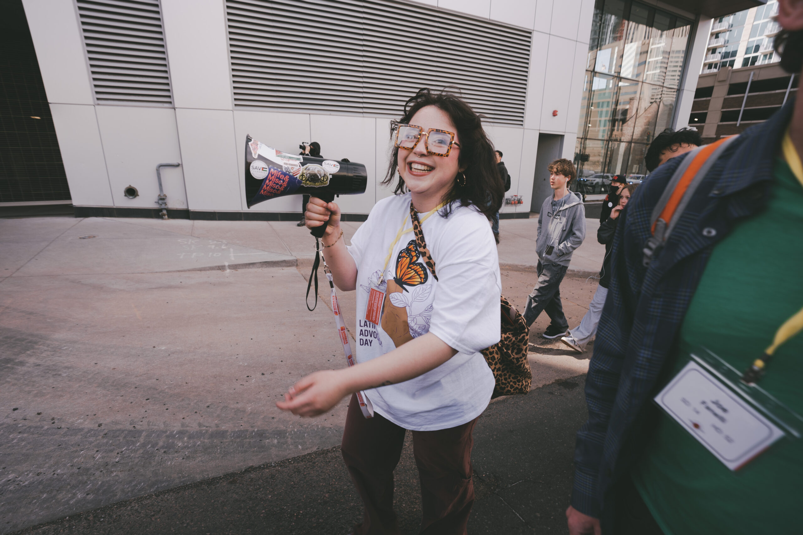 A joyful young woman holds a bullhorn and leads a march